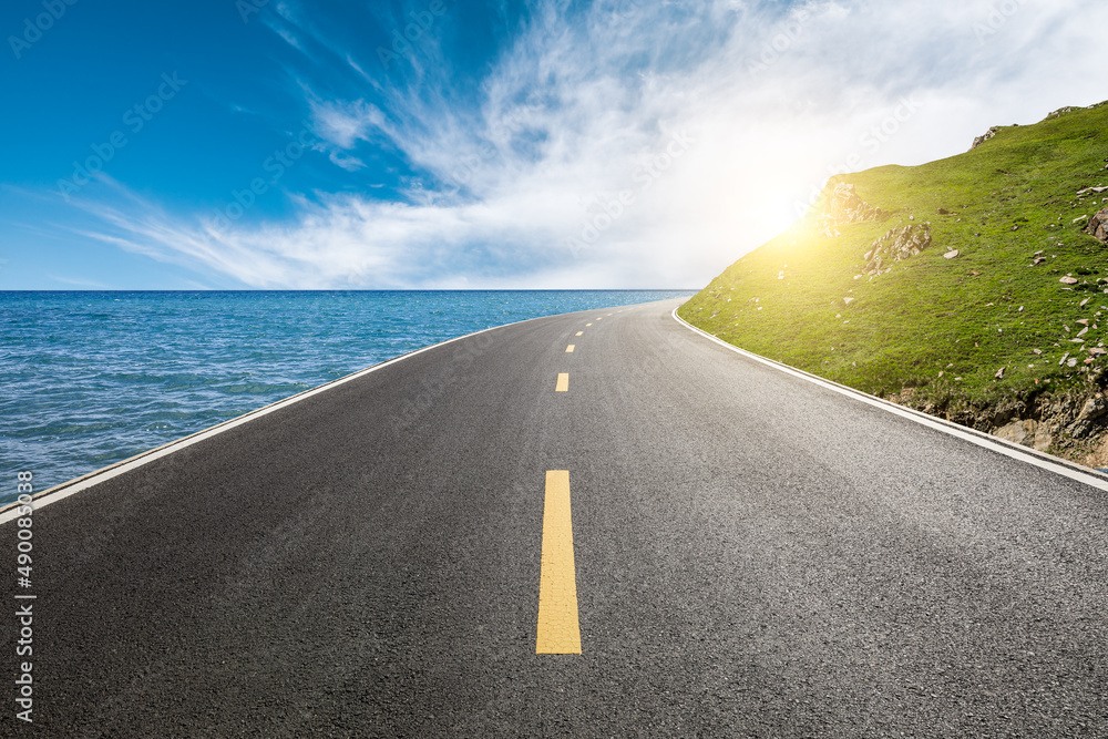 Asphalt road and mountain with sea natural scenery under blue sky