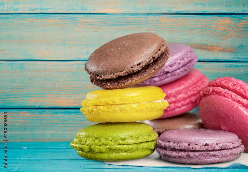 French dessert for coffee. Multicolored macarons or macaroons on desk