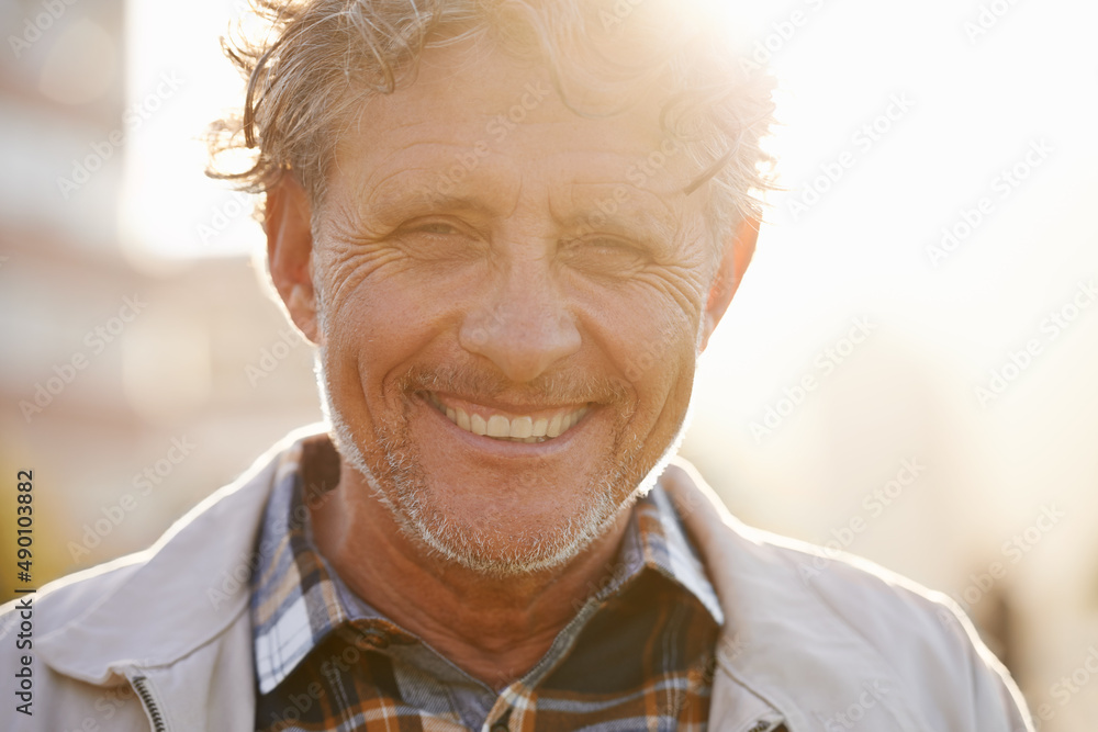 Hes got a sunny outlook on life. Portrait of a friendly-looking middle aged man outside.