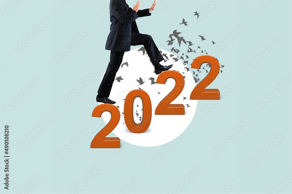 A man climbs the 2022 text like stairs. New challenges and successes in 2022. Art collage.