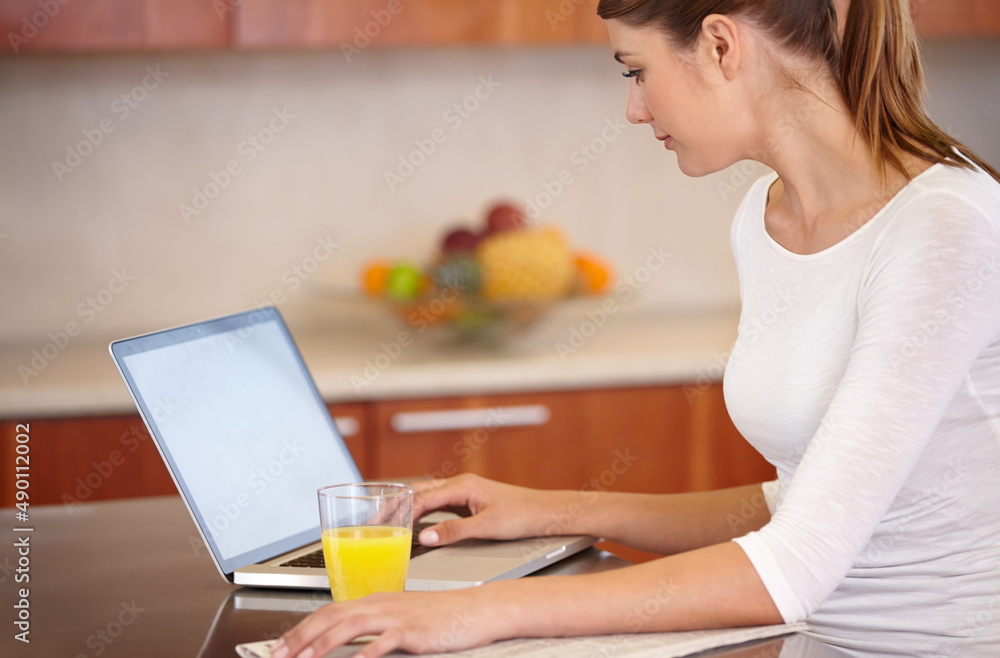 Catching up on current events. Cropped shot of an attractive young woman using her laptop while rela