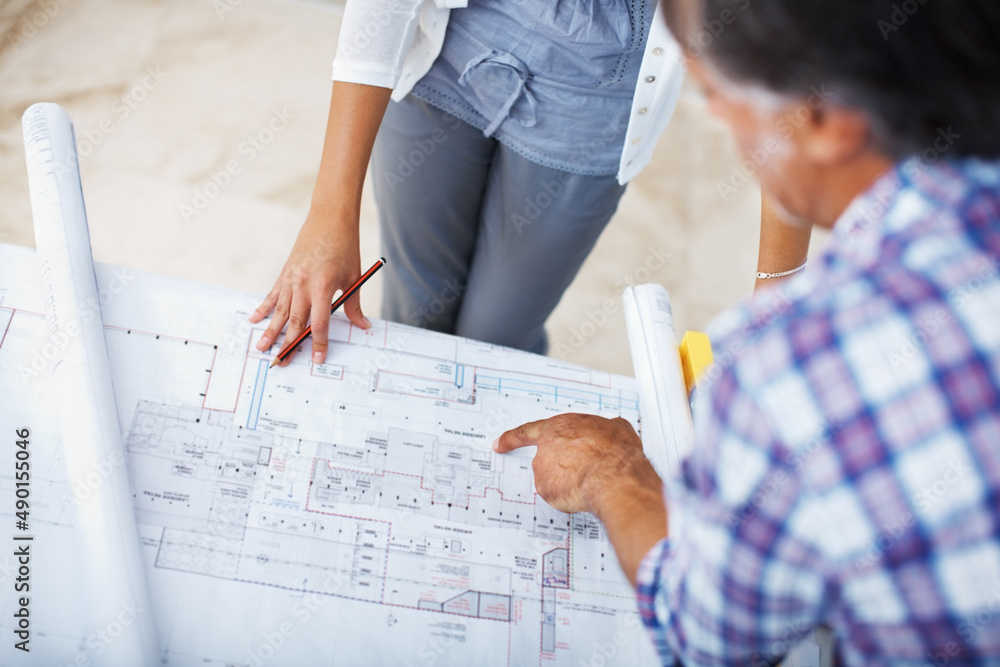 Architect showing plan to female client. Closeup of architect showing plan to female client.