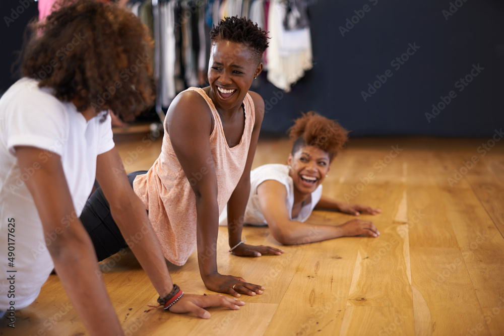 The lighter side of getting limber. Shot of a group of young dancers rehearsing together in a studio