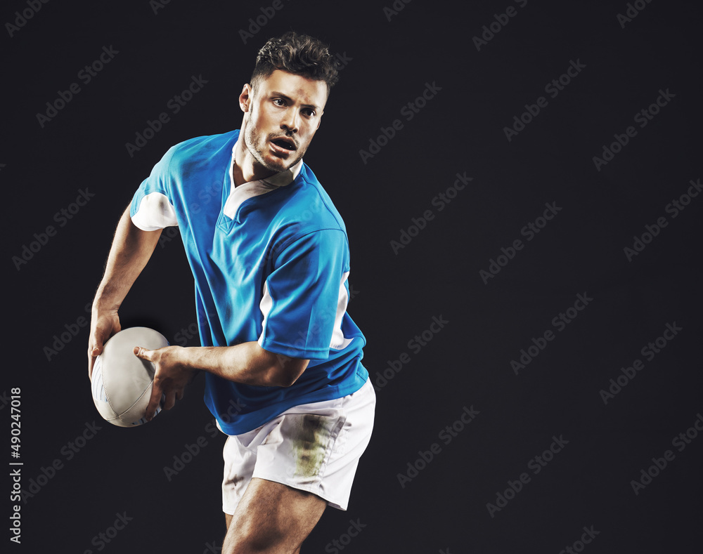 Time for a try. Studio shot of a rugby player passing the ball against a black background.