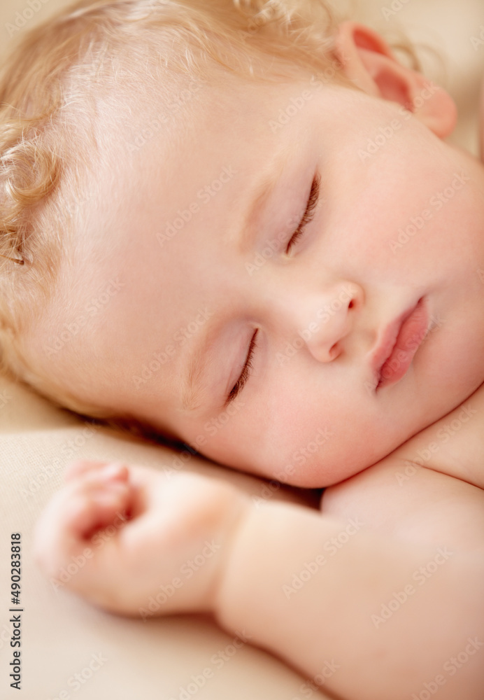 Napping soundly. Tiny baby boy lying fast asleep.