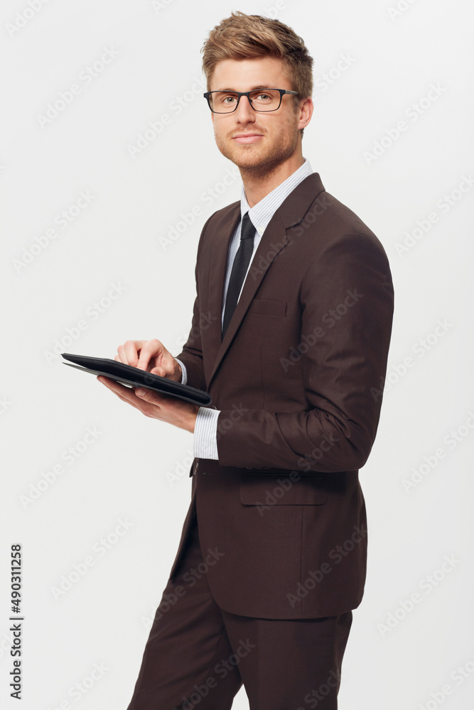 Working on the go.... Studio portrait of a stylishly-dressed young businessman holding a digital tab