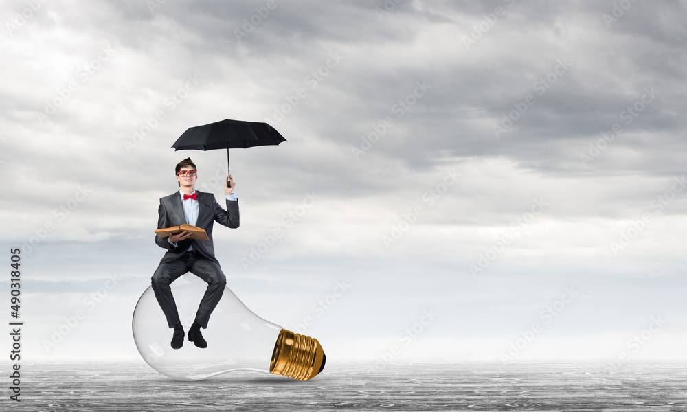 young businessman with an umbrella and a book