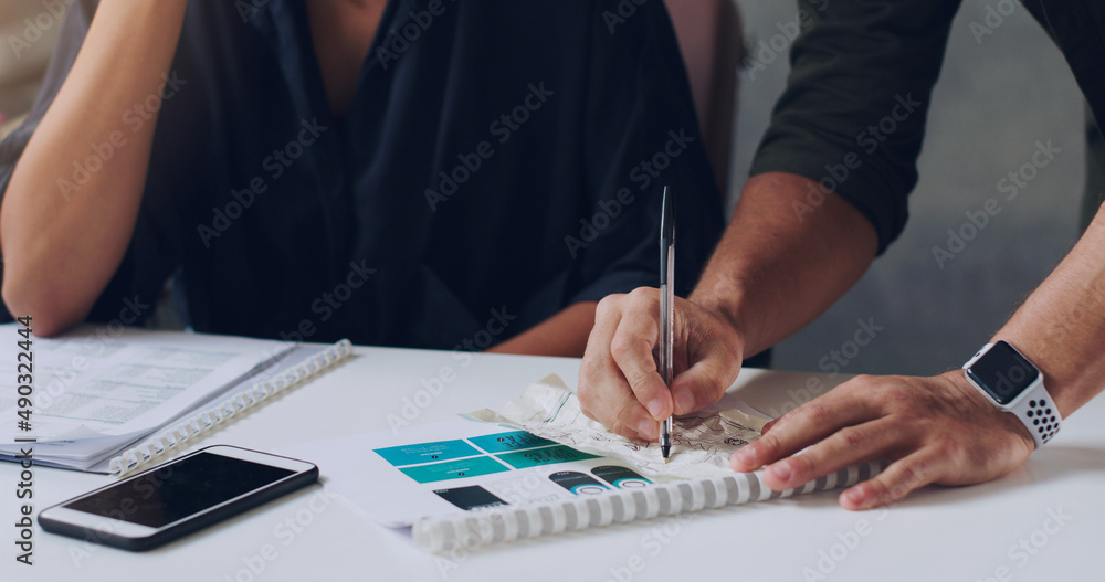 Making a few notes. Cropped shot of two unrecognizable businesspeople working together in the office