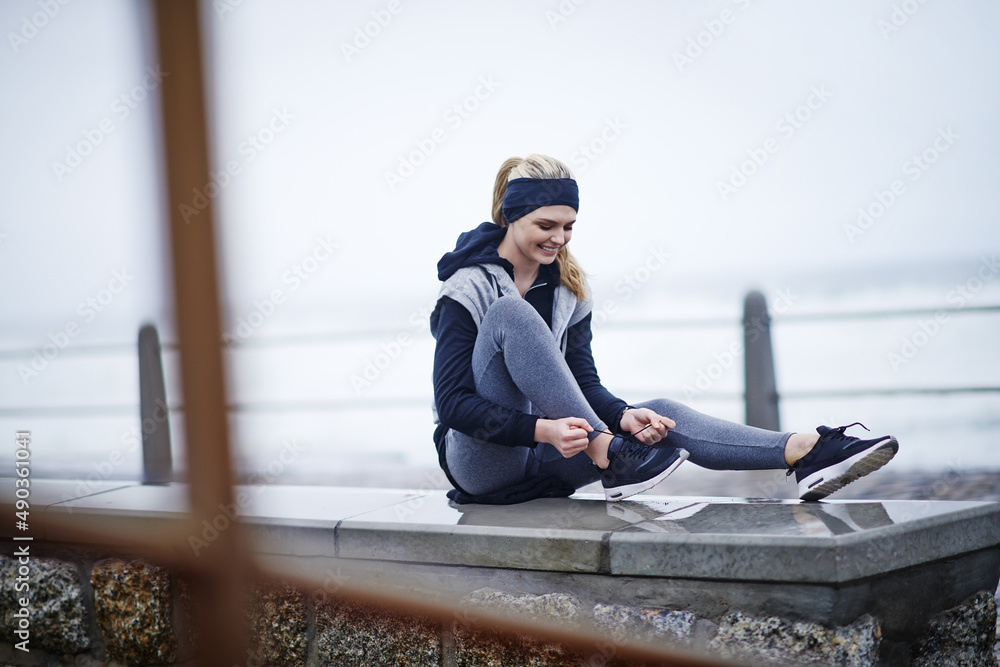 是时候让这些脚上街了。一张年轻女子在跑步前系鞋带的照片。