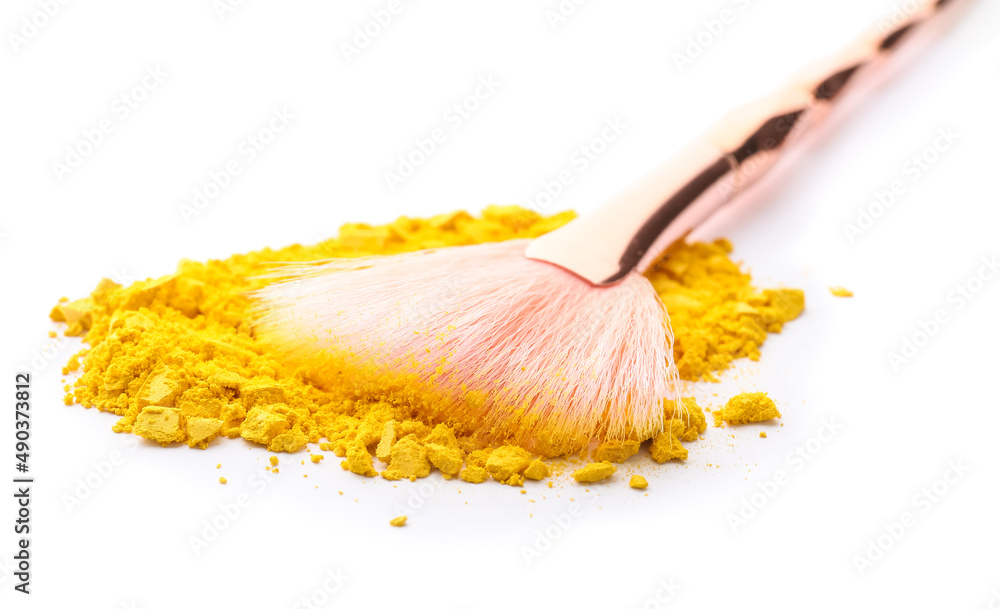 Makeup brush and loose eye shadow on white background