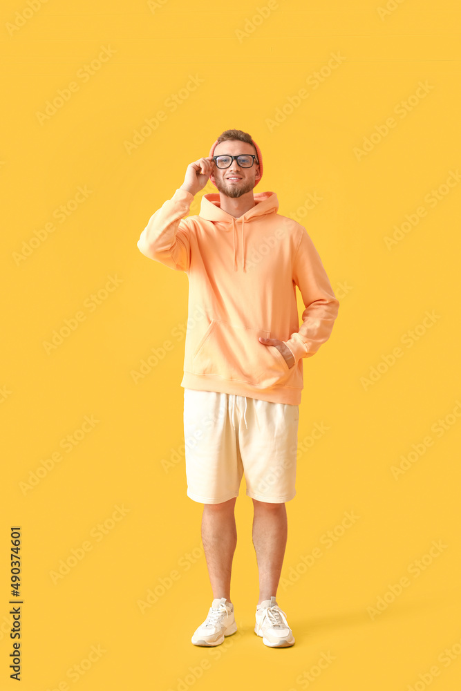 Young guy in stylish hoodie on color background