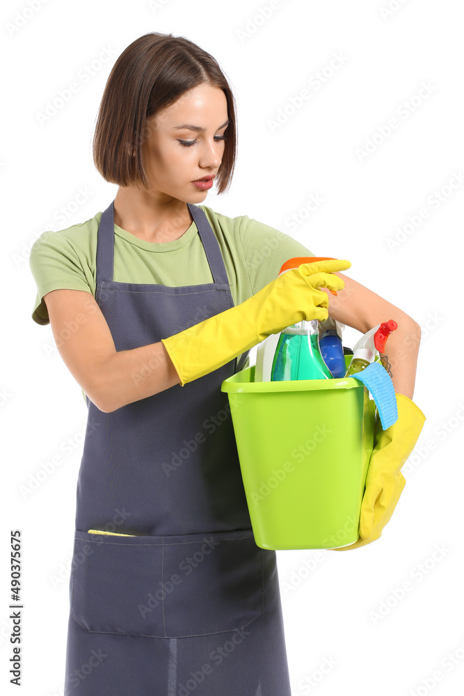 Beautiful young woman with cleaning supplies on white background