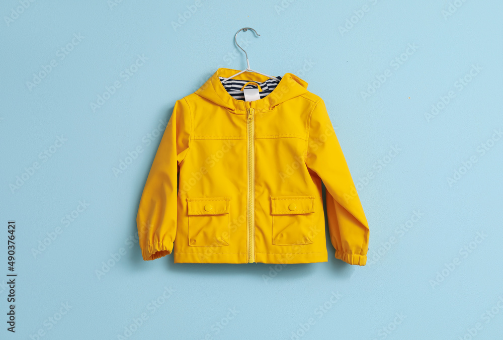 Childs raincoat hanging on blue wall