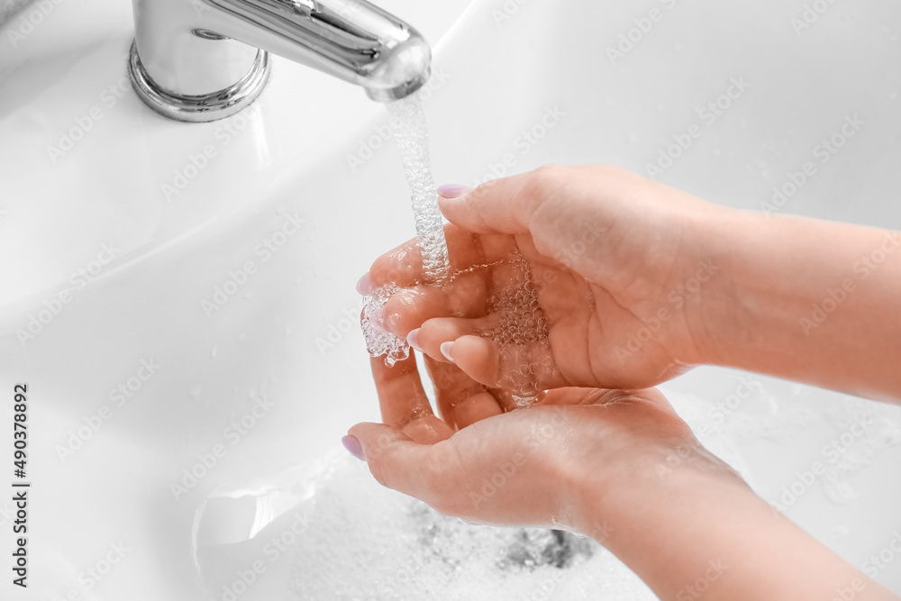 Woman washing her hands in ceramic sink, closeup