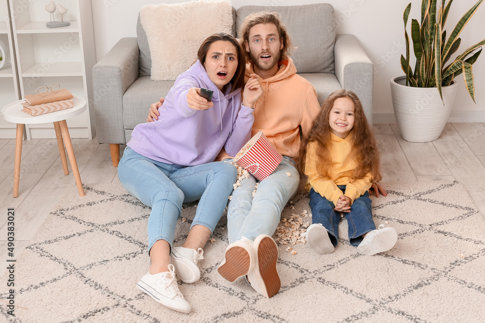 Young family watching movie together at home