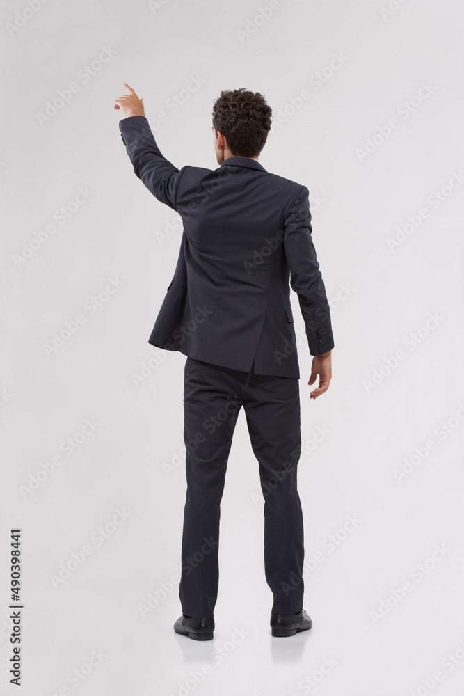 The only way forward is with technology. Rear view of a handsome young businessman touching a transp