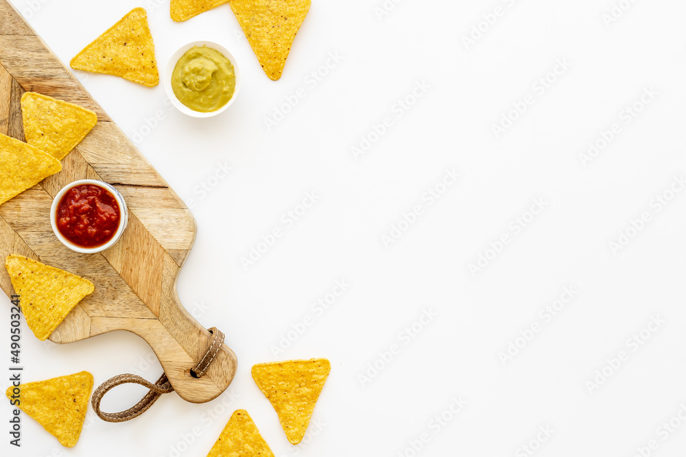 Tortilla nachos chips with red tomato salsa and avocado guacamole