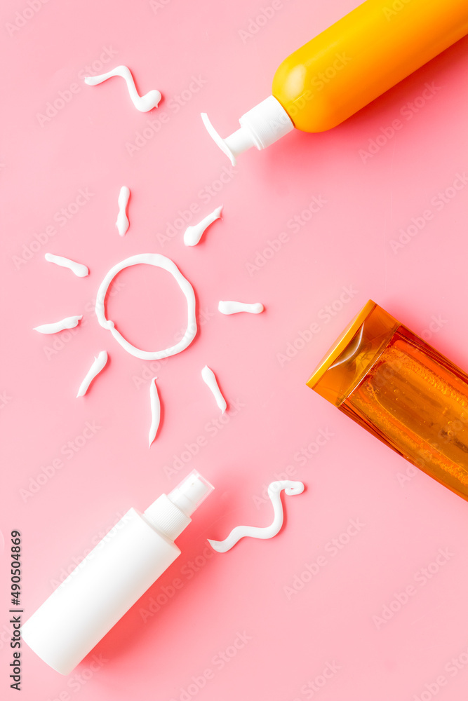 Sunscreen in bottles flatlay with sun made of white cream