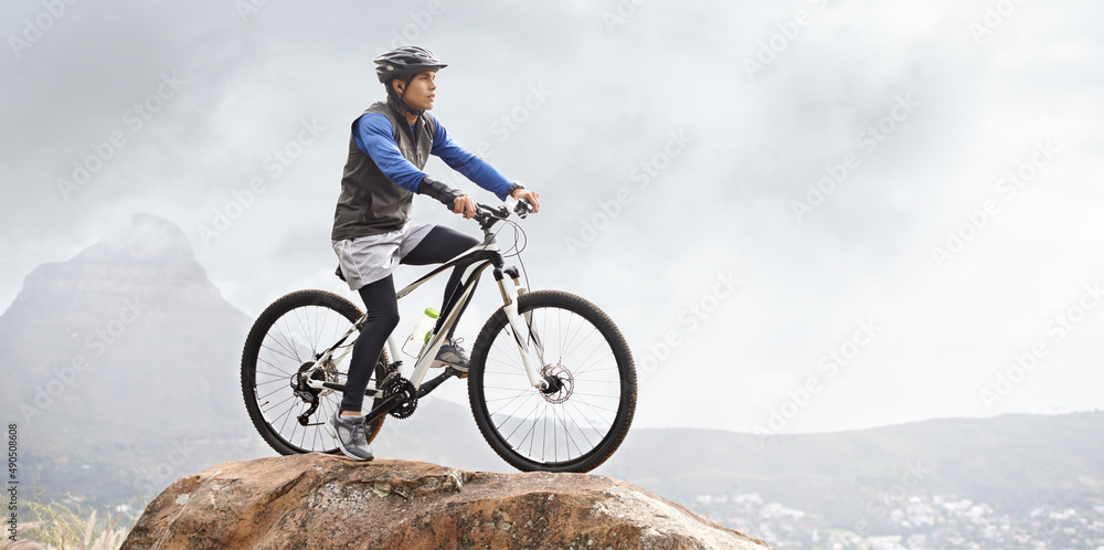 Out for a mountain bike ride. A young man on a mountain bike with a gorgeous view in the background.