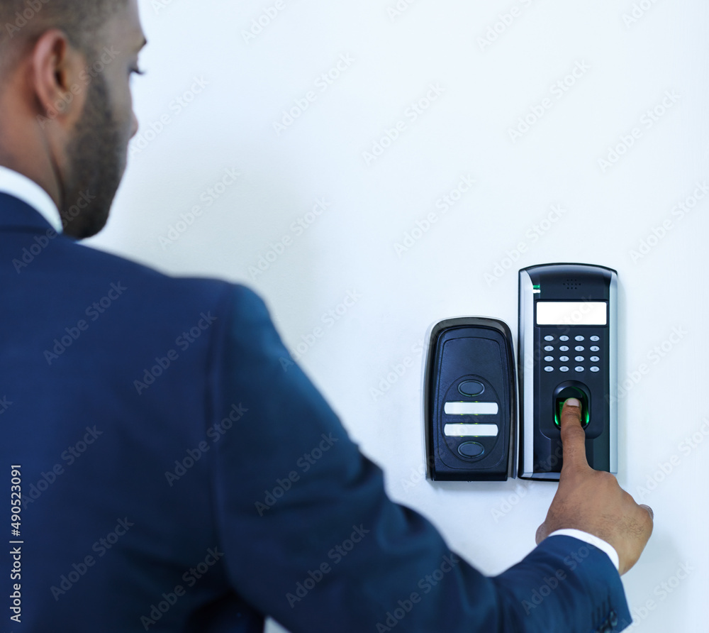 Being security conscious. A cropped rear view of a young african american businessman scanning his f