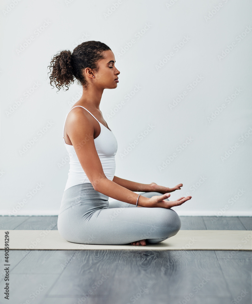 Yoga help me with so much in life. Shot of a sporty young woman practising yoga.