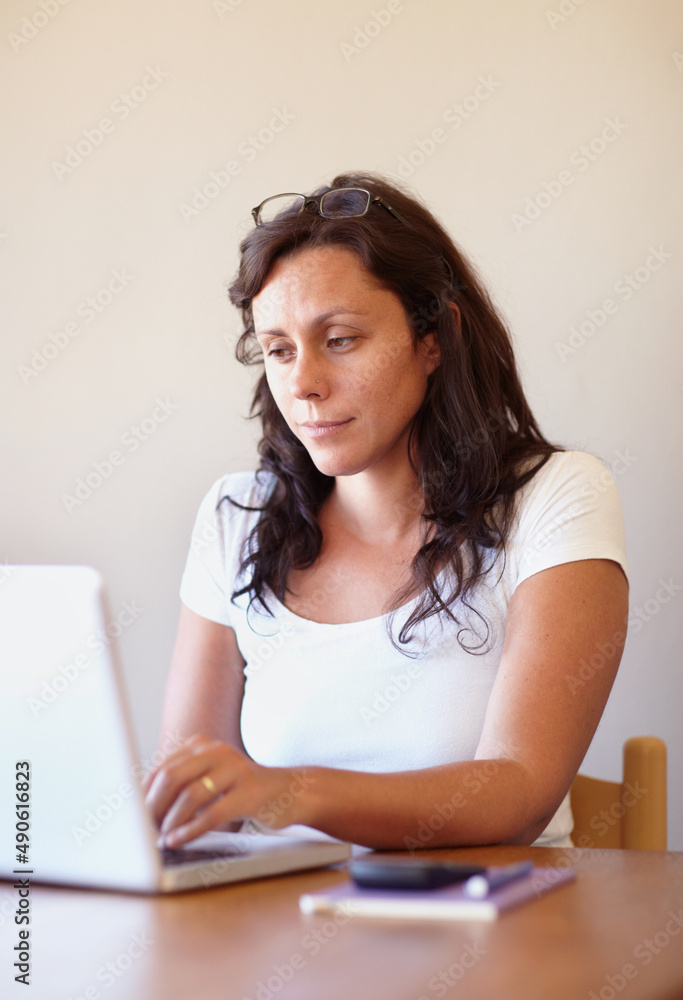 Starting up her first business. Cropped view of a casually dressed entrepreneur working on her lapto