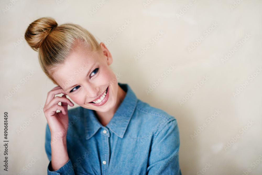 Smiling shyly. A beautiful young woman in casualwear - studio shot.