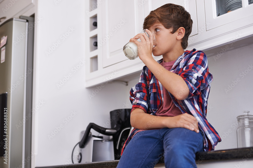 Enjoying his daily glass of milk. A young boy drinking a glass of milk.