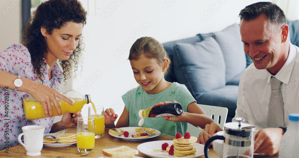 What better way to start the day than with family. Shot of a cute little girl having breakfast with 