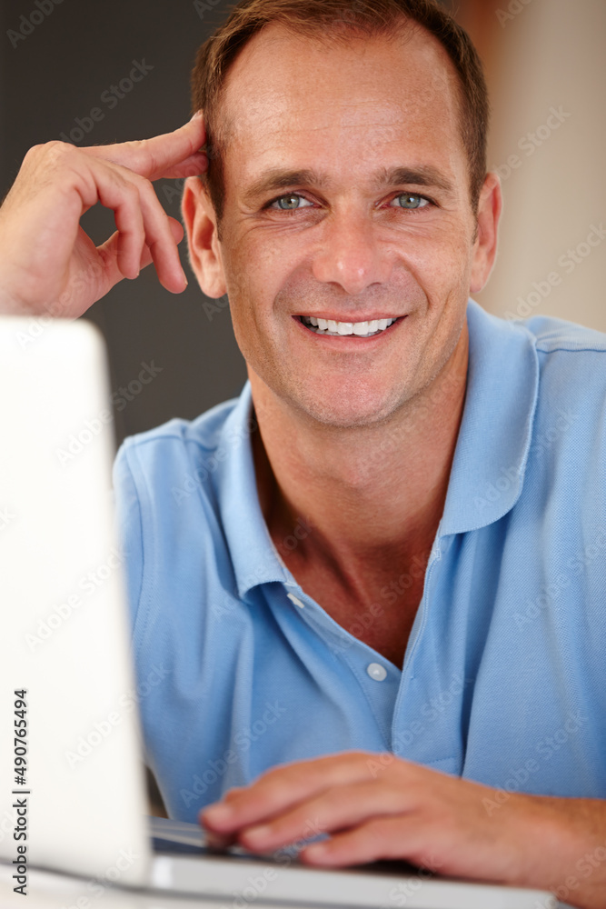 Internet is the town square for the global village. Portrait of a mature man using a laptop indoors.