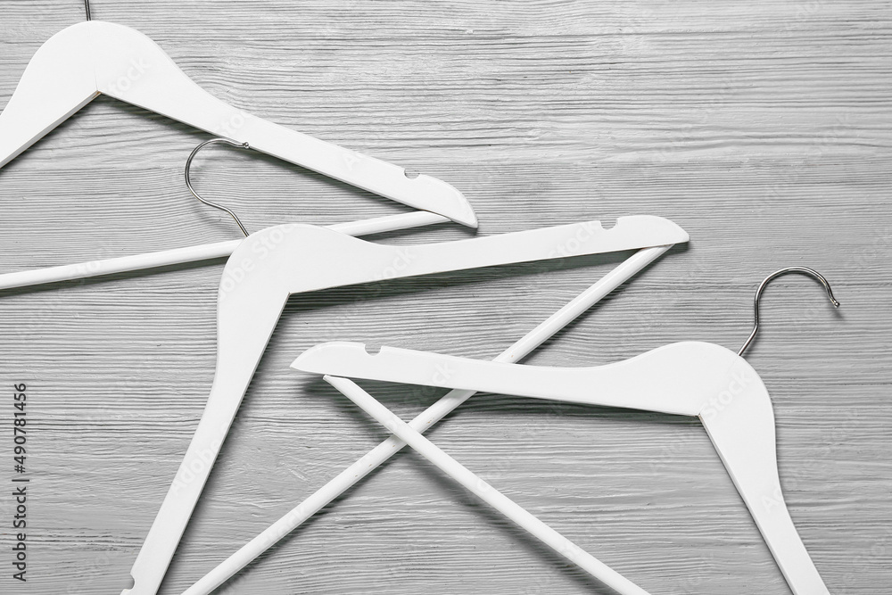 Clothes hangers on grey wooden background