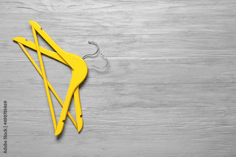 Clothes hangers on grey wooden background