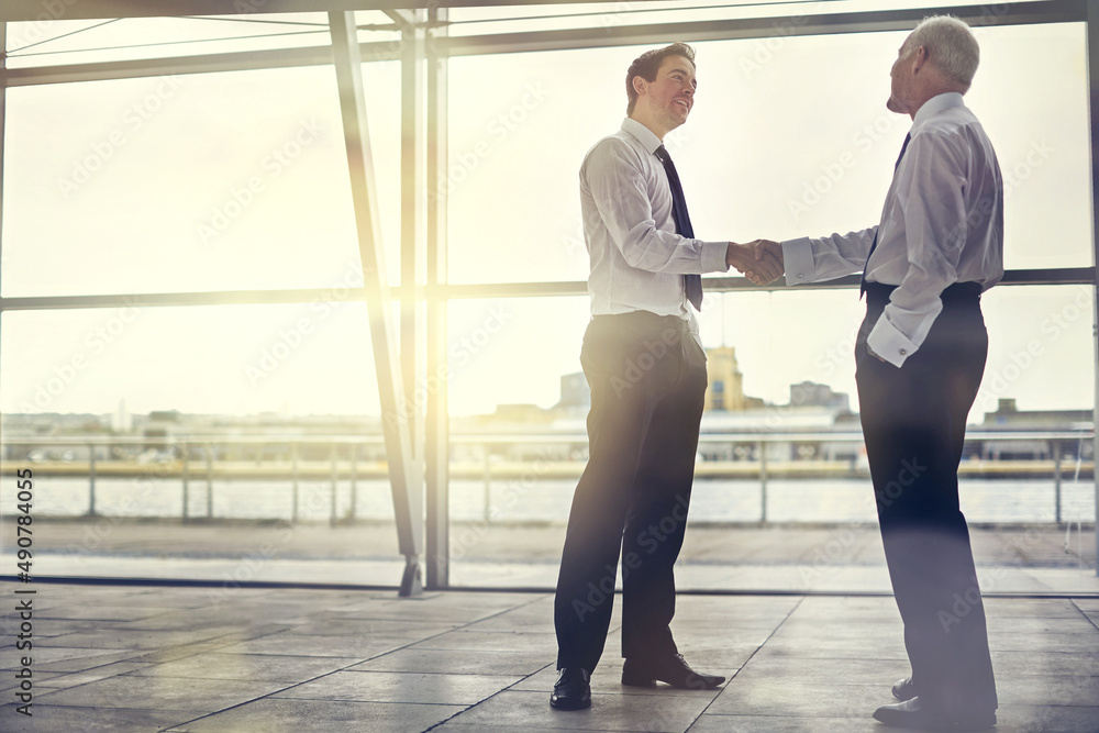 Im looking forward to working with you. Full length shot of two businessmen shaking hands in the lob