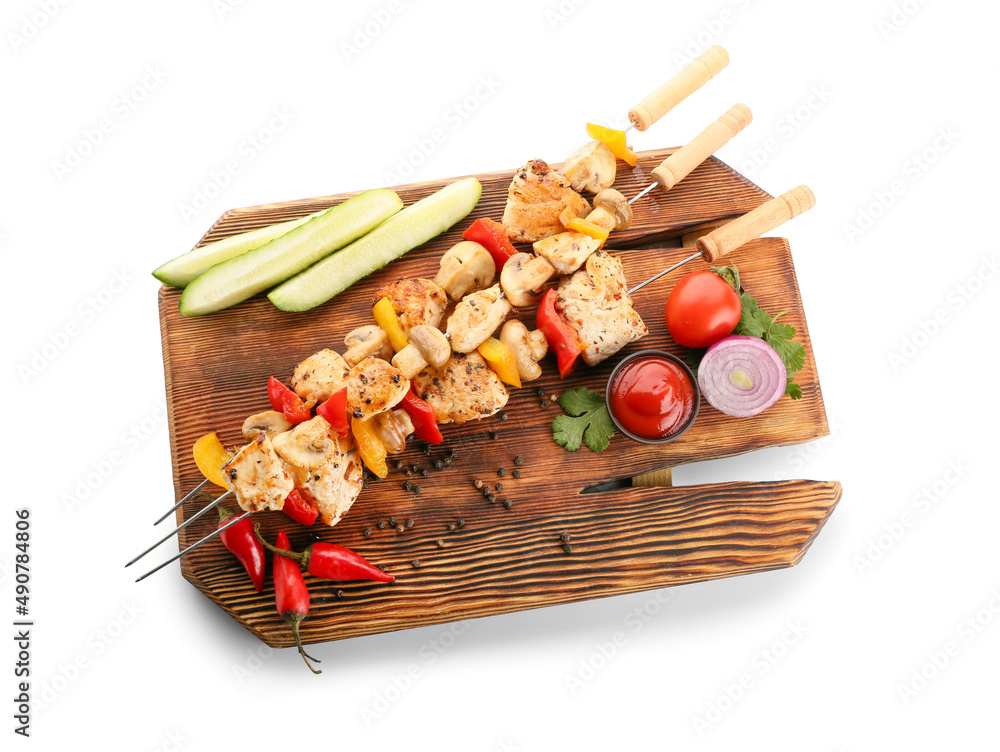 Wooden board of grilled chicken skewers with vegetables isolated on white background