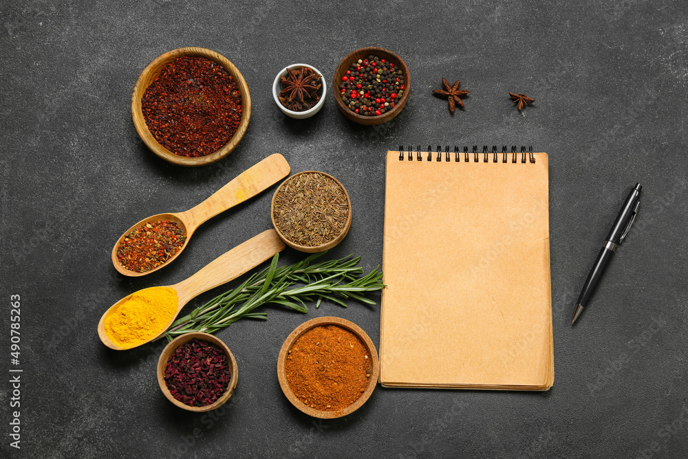 Composition with different spices, blank notebook and pen on dark background