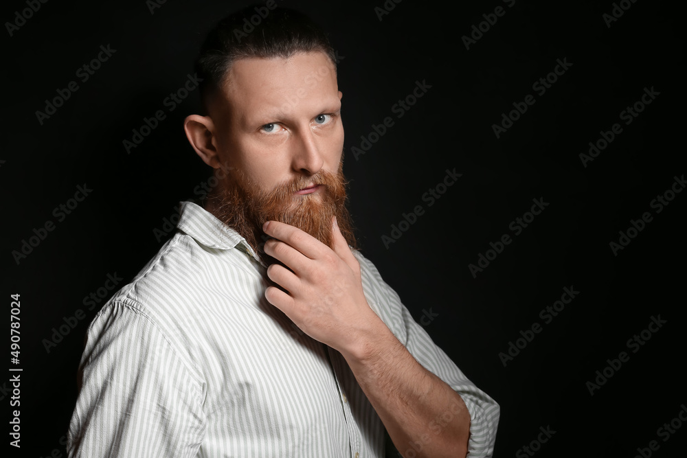 Portrait of handsome bearded man on dark background