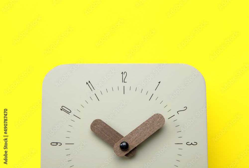 New alarm clock on yellow background, closeup