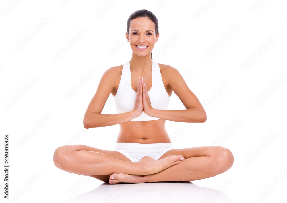 Keeping fit for mind and body. Studio shot of a young woman in the lotus position isolated on white.