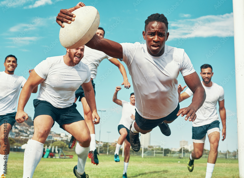 This is for my team. Shot of a rugby player scoring a try while playing on a field.