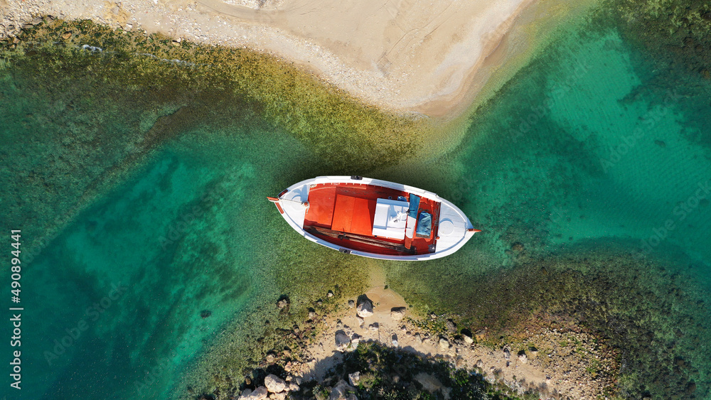 Aerial top view photo of red traditional wooden fishing boat anchored in Aegean island destination p