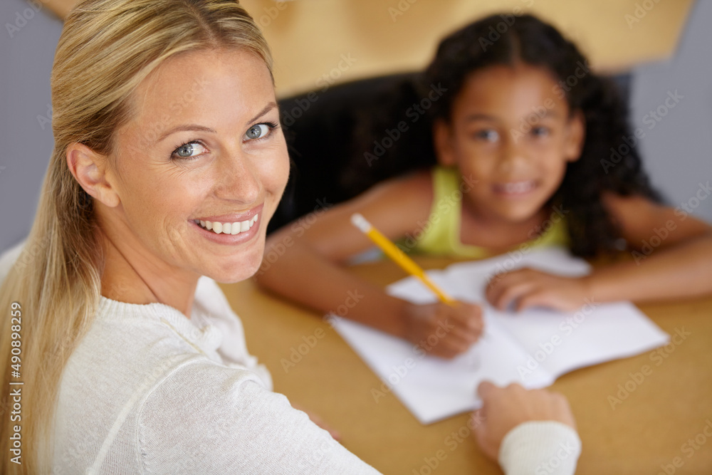 Shes a dedicated educator. Portrait of a pretty teacher helping her student with homework.