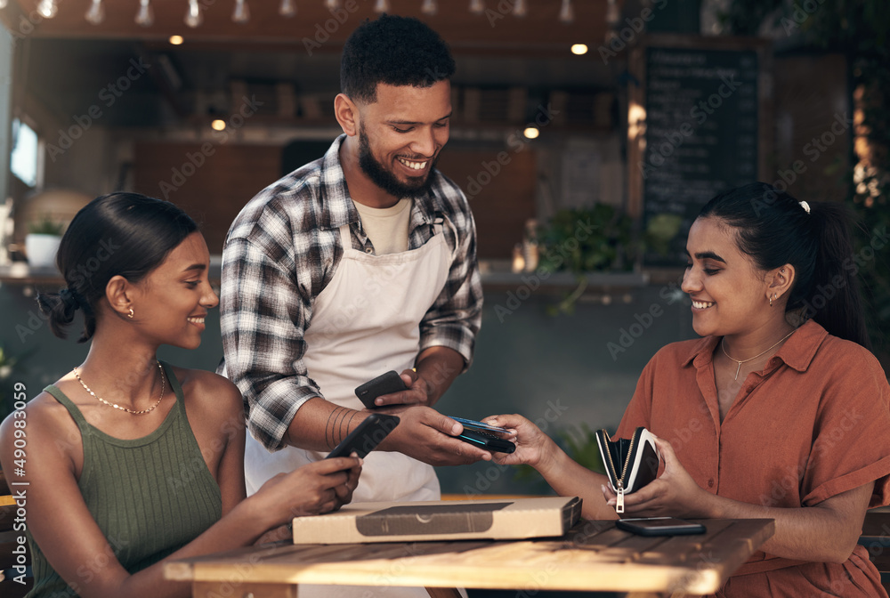 Dont worry, Ive got this one. Shot of two young women sitting at a restaurant and using a credit car