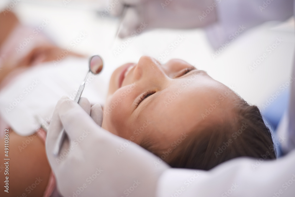 Her Dentist is the BEST Dentist. Cropped shot of a little girl getting her teeth checked.