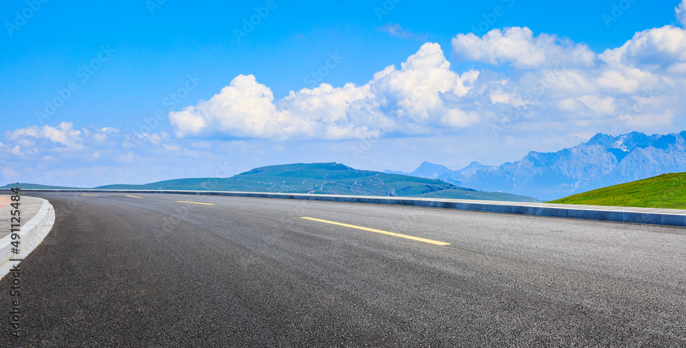 空旷的柏油路，蓝天下的青山自然风光