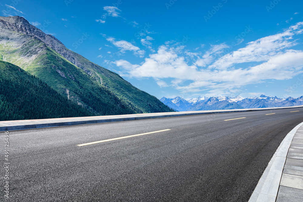 空旷的柏油路和蓝天下的山地自然风光。道路和山脉的背景。