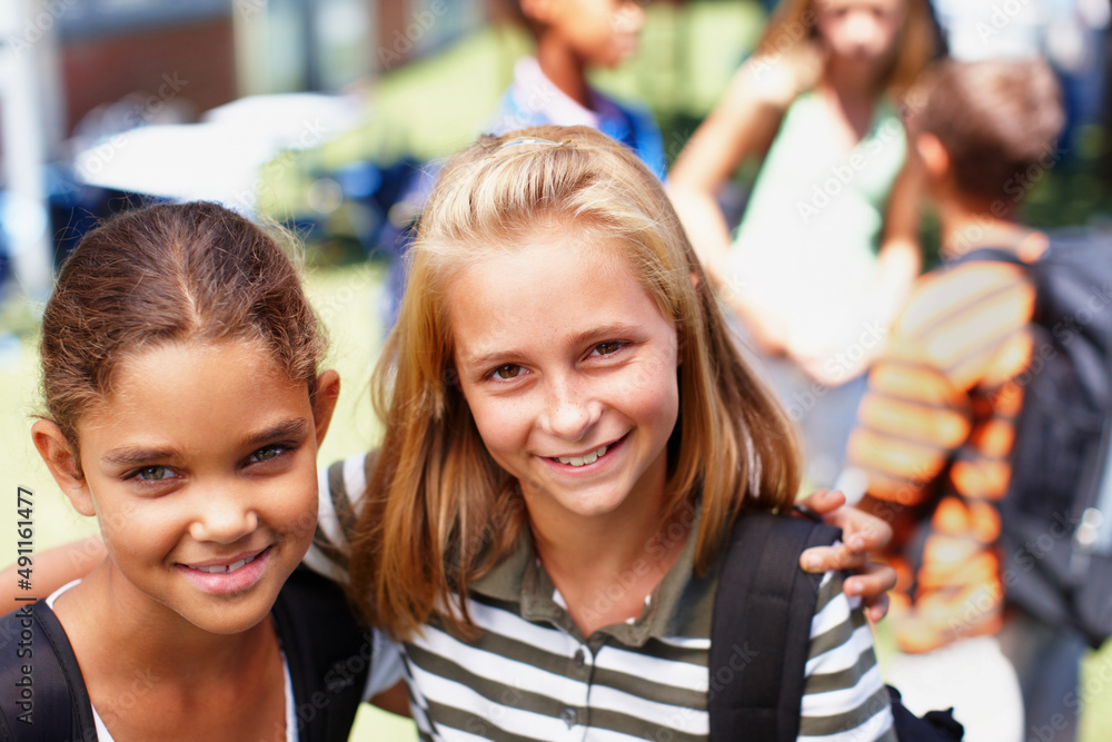 We love hanging out at school together. Two schoolgirl friends standing next to each other smiling u