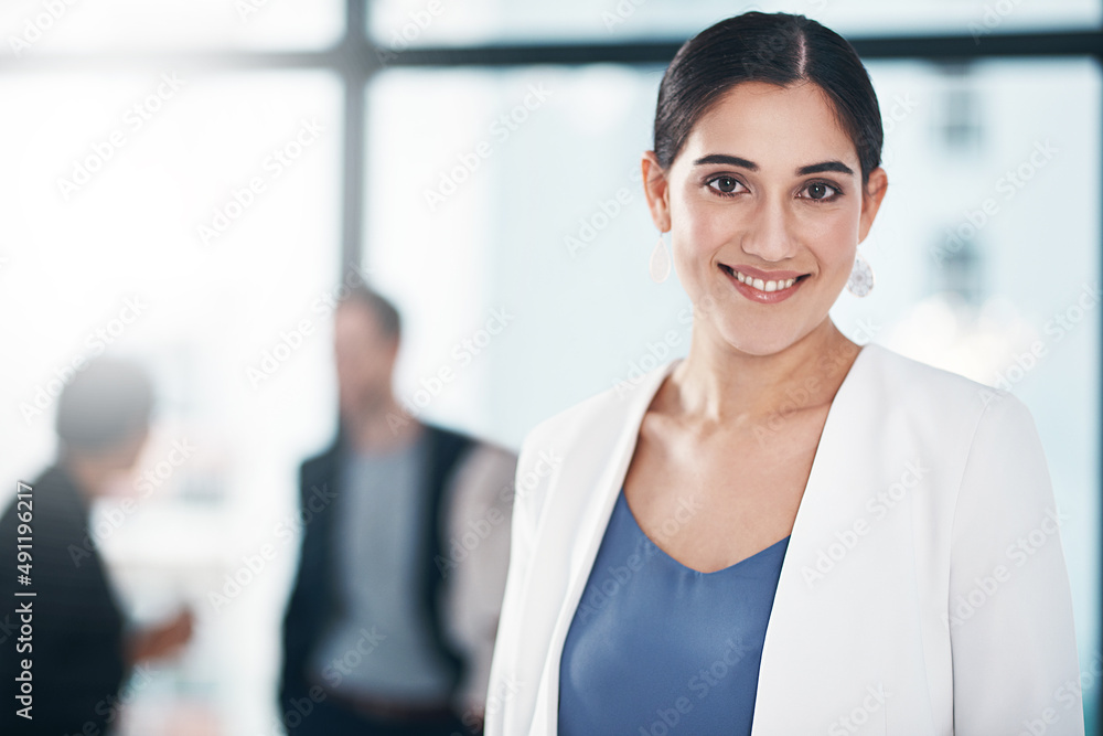 She works to attain increasingly higher goals. Portrait of a businesswoman in an office with her col