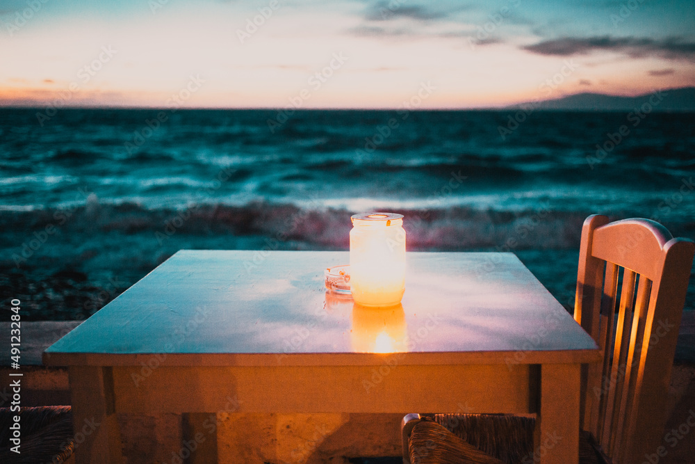 夜晚海边燃着蜡烛的浪漫餐桌