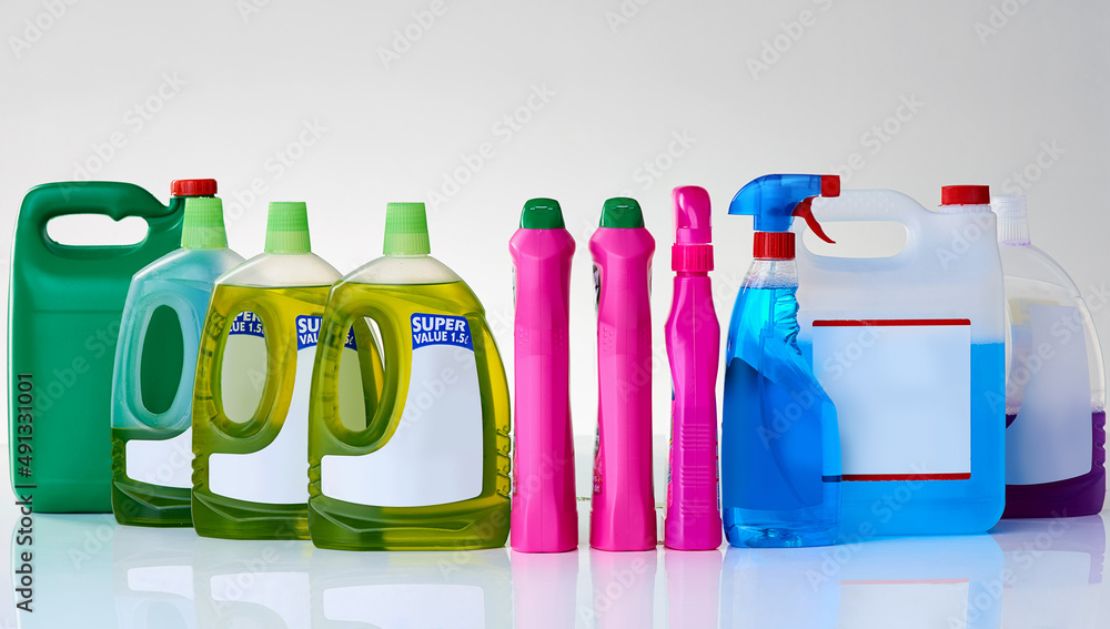 Domestic detergents. Studio shot of various bottles of detergents against a grey background.