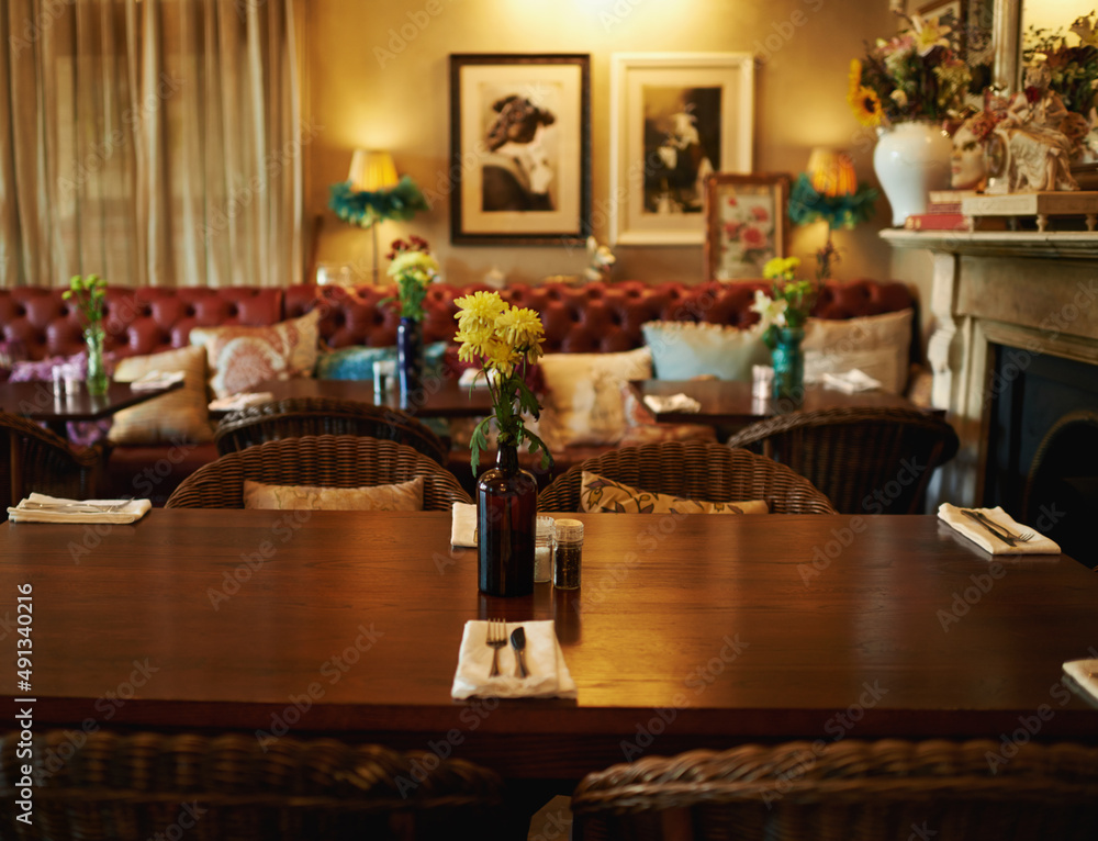 Shall we be seated. Shot of a cozy home interior with a set dining table in the foreground.